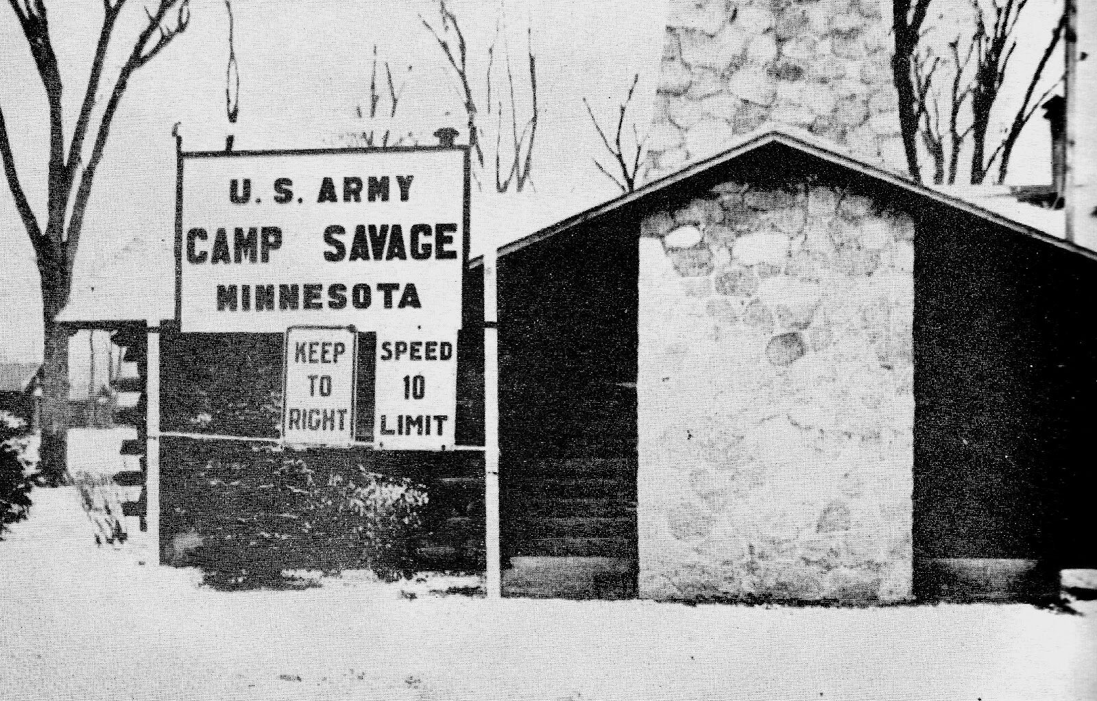 A snowy winter scene of the entrance to Camp Savage.