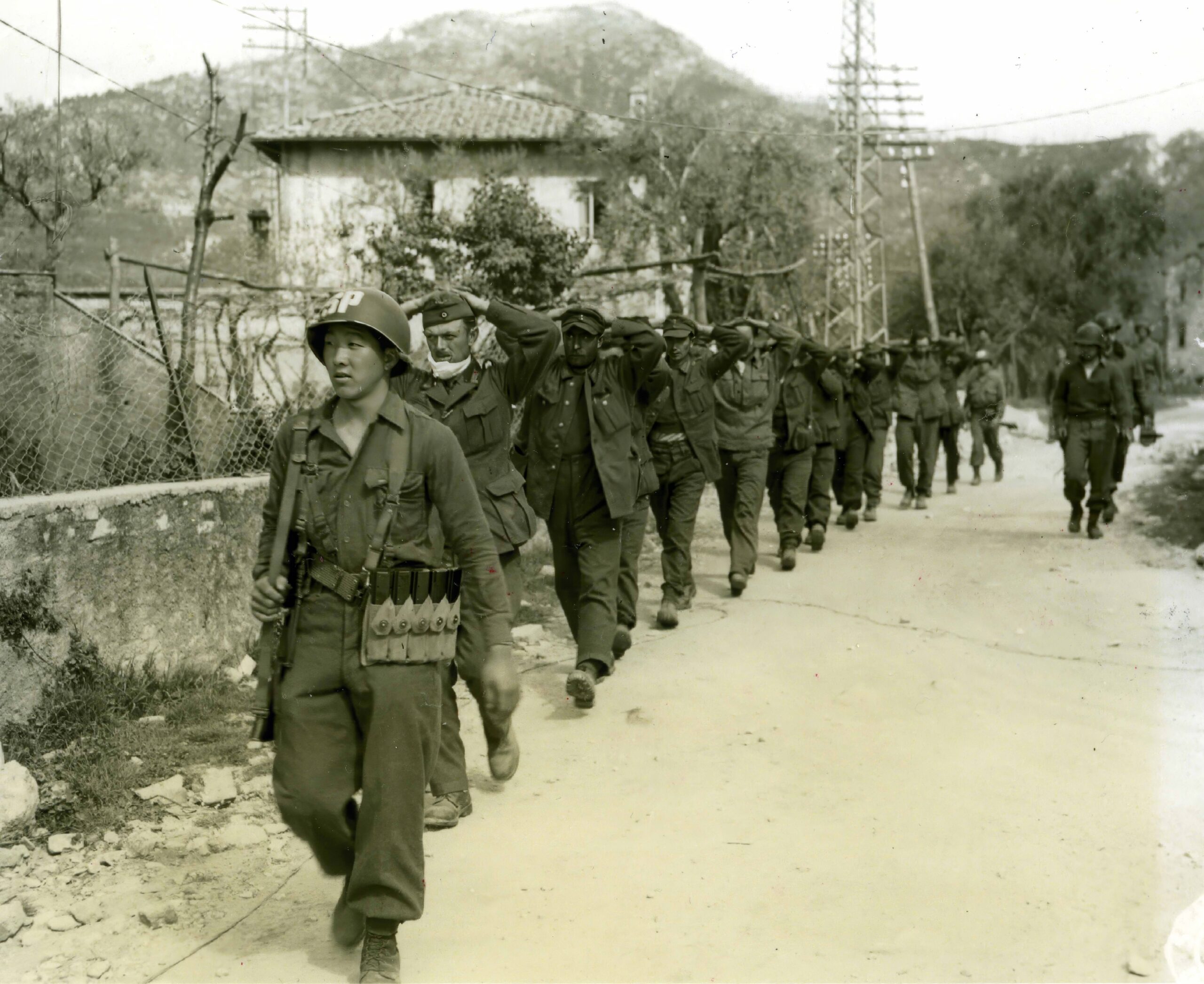 A 442nd soldier escorting prisoners in Italy during World War II