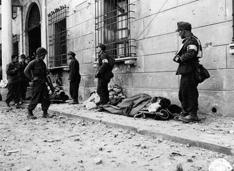 Japanese-American soldier guarding German prisoners.